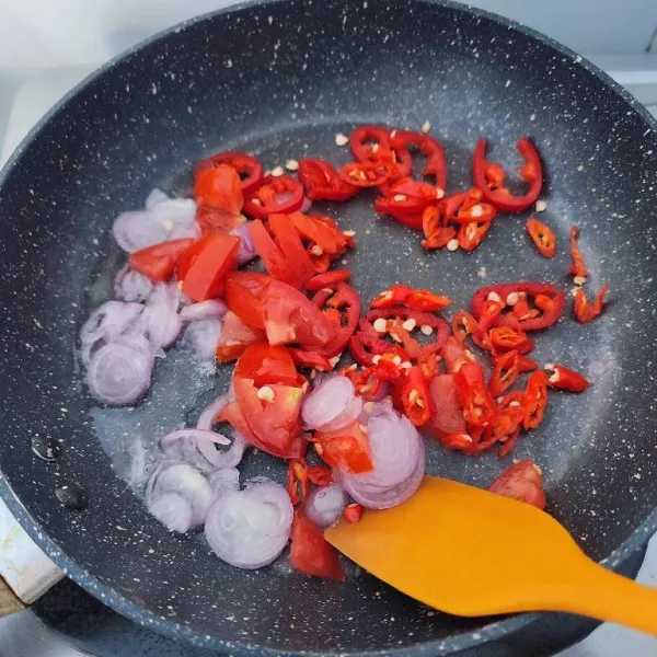 Kemudian panaskan minyak, tumis bawang merah, cabe rawit, cabe merah besar dan tomat merah hingga setengah layu.