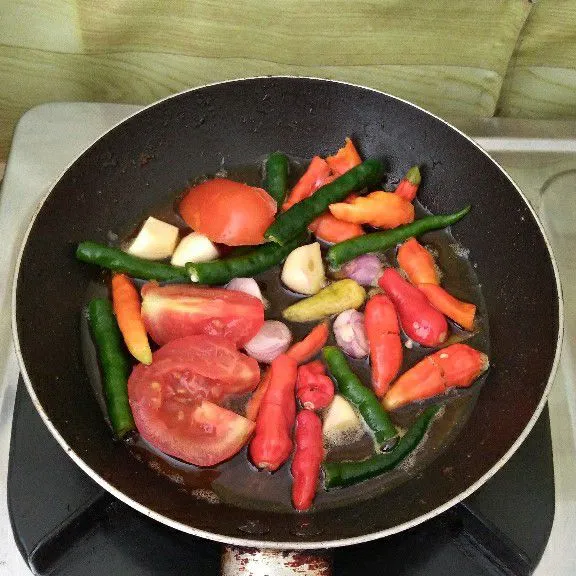 Goreng cabe, bawang merah, bawang putih, dan tomat hingga matang lalu angkat.