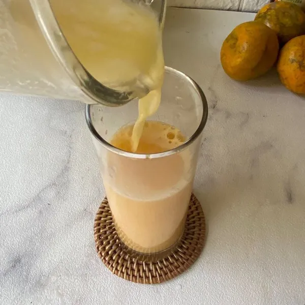 Tuang jus nanas ke dalam gelas yang berisi air perasan jeruk. Aduk lalu sajikan.