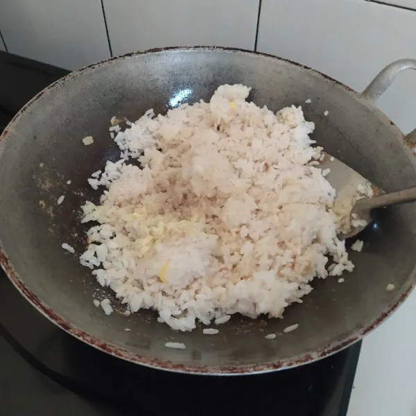 Masukan nasi, telur yang telah diorak arik, bumbui dengan garam, lada dan kaldu bubuk. Tumis hingga bumbu tercampur rata.