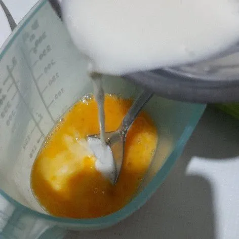Tuang campuran tepung dan air ke dalam telur, kocok lalu aduk rata.