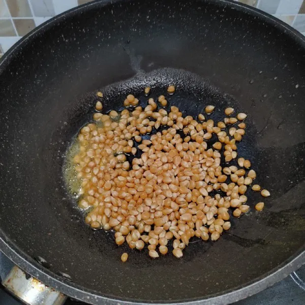 Panaskan wajan dan lelehkan margarin, kemudian masukan jagung popcorn lalu tutup wajan dan biarkan hingga jagung meletup-letup menjadi popcorn.