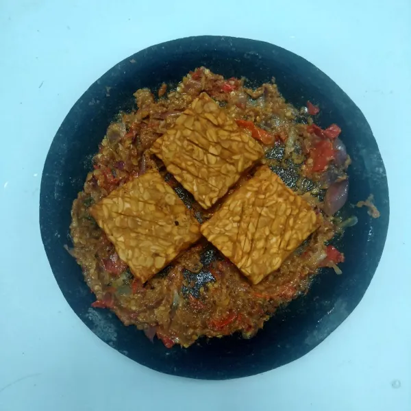 Taruh tempe goreng di atas sambal kemudian penyet tempe dan siap disajikan.