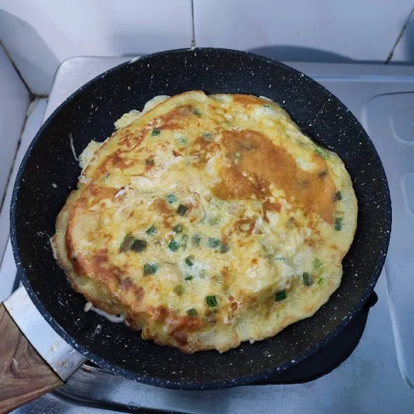 Balik omelette ketika bagian bawah sudah kecokelatan, kemudian masak sisi satunya sampai matang. Angkat, tiriskan dan sajikan.