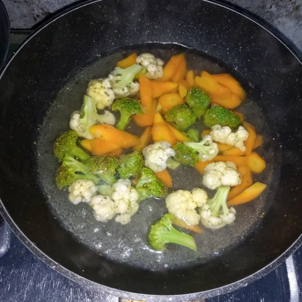 Rebus wortel setengah matang. Masukkan brokoli dan kembang kol. Rebus sebentar sampai mendidih. Angkat dan tiriskan.