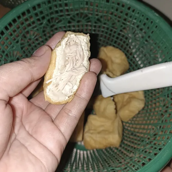 Belah tahu menjadi bentuk segitiga, lalu buang isi nya. Kemudian isi dengan secukupnya adonan dan beri secukupnya suwiran ayam di atas adonan.