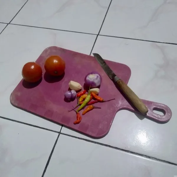 Potong tomat dadu lalu pisahkan terlebih dahulu, selanjutnya cincang bawang merah, bawang putih dan cabai.