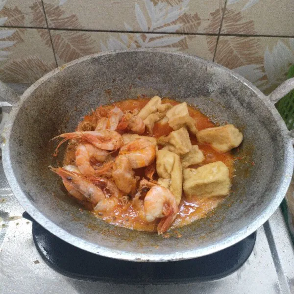Masukkan tahu dan udang, aduk pelan sampai bumbu meresap dan tidak ada kandungan air. Koreksi rasa dan angkat.