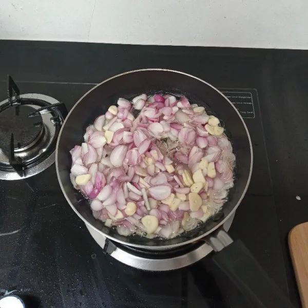 Panaskan minyak, masukkan bawang merah dan bawang putih, masak hingga setengah matang sambil terus diaduk.