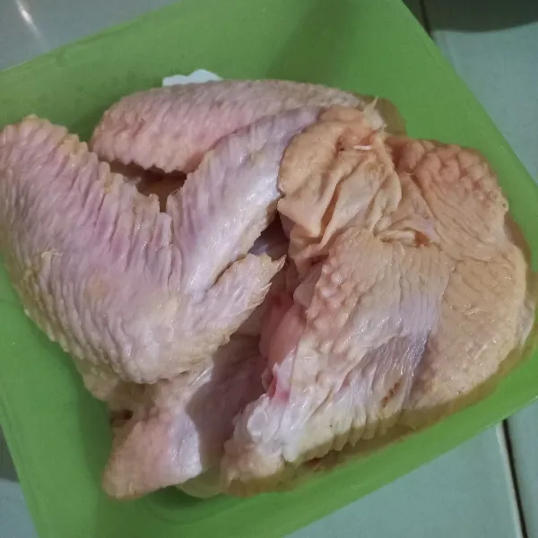 Bersihkan sayap ayam, kemudian masing-masing potong menjadi dua bagian, sisihkan.
