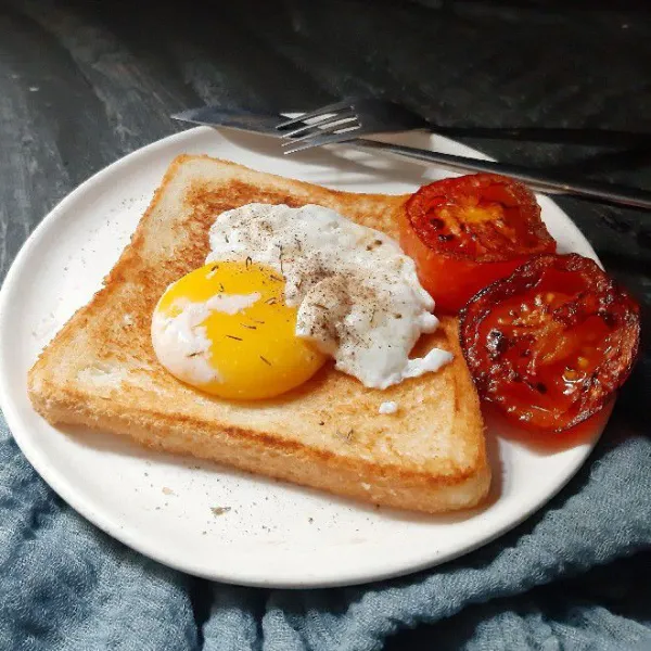 Sajikan roti bersama telur dan tomat panggangnya. Beri taburan.