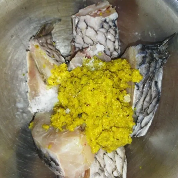 Haluskan bawang putih, ketumbar, kemiri, jahe dan kunyit, lalu masukkan bumbu halus ke dalam ikan, tambahkan juga garam.