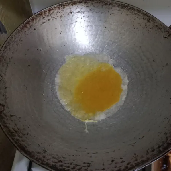 Panaskan wajan dengan sedikit minyak lalu ratakan, tata kulit lumpia pada wajan lalu tuang setengah bagian telur.