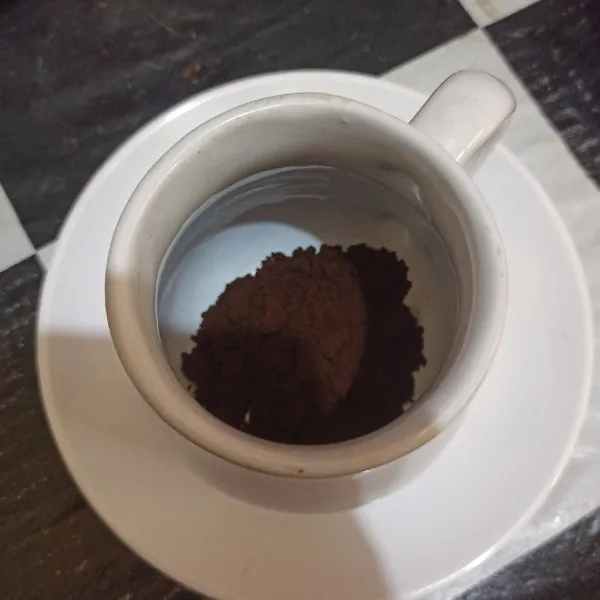 Tuang kopi bubuk ke dalam gelas.