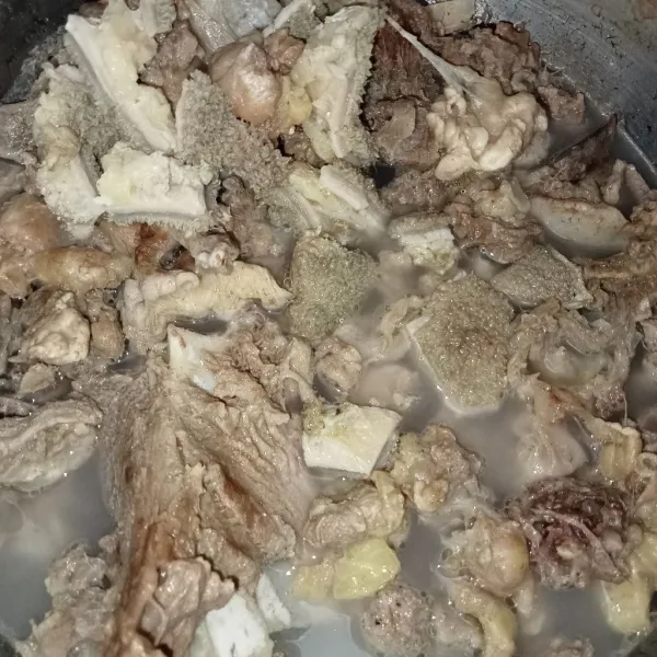 Rebus tulang dan semua bagian daging kambing menjadi satu rebus hingga empuk. Buang air rebusan daging.