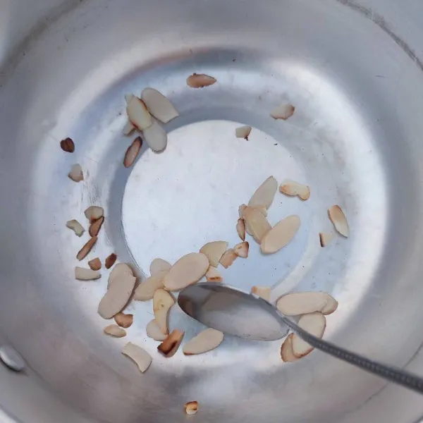 Sangrai kacang almond slice atau kacang kenari slice hingga kecokelatan, lalu sisihkan.
