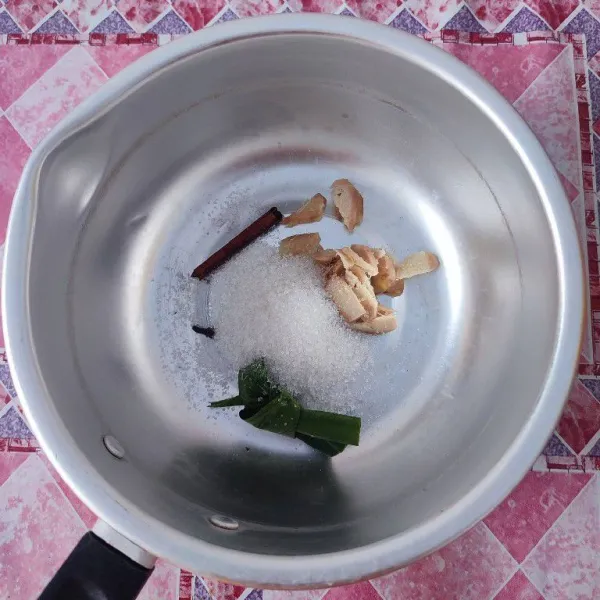 Masukkan jahe iris, cengkeh, kayu manis, daun pandan, garam dan gula pasir ke dalam panci.