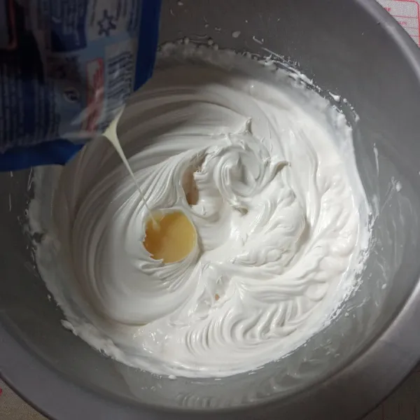 Kocok whipped cream dengan kecepatan rendah sampai soft. Masukkan kental manis, kocok lagi sampai kaku.