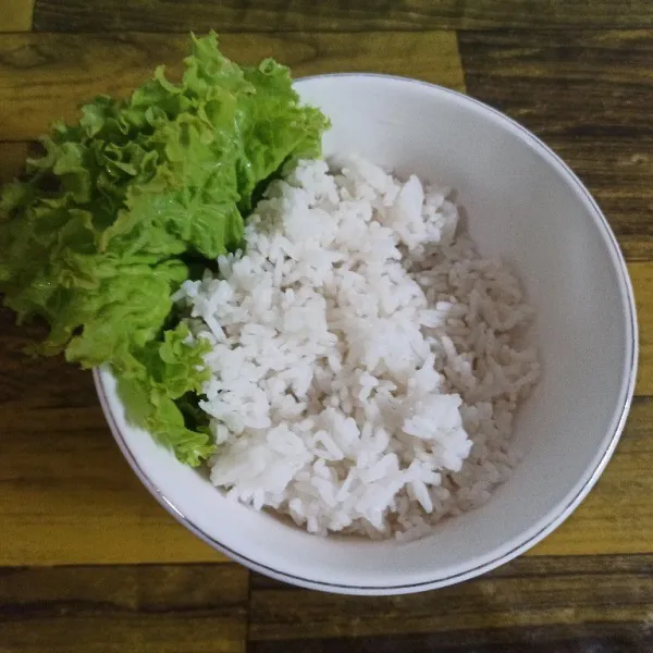 Siapkan mangkuk, tata selada keriting kemudian tambahkan nasi hangat secukupnya. Setelah itu tambahkan orak-arik telur bakso, sajikan.