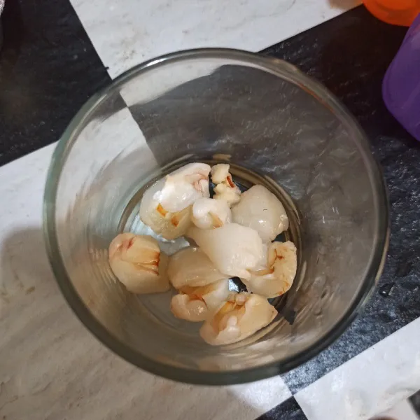 Kupas buah leci lalu potong kecil, letakkan di dalam gelas.