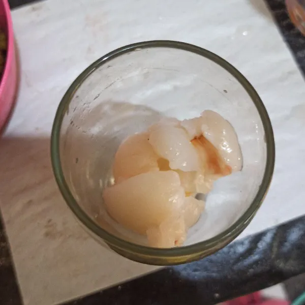 Kupas buah leci lalu letakkan di dalam gelas.
