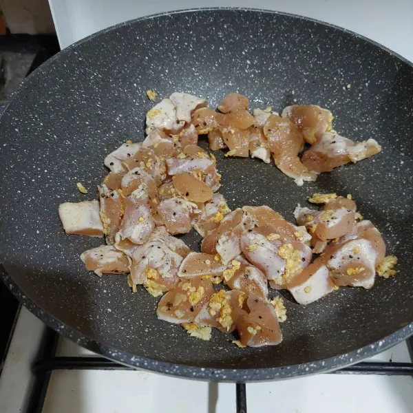 Tumis bawang putih hingga harum lalu masukkan ayam marinasi, masak hingga mulai berubah warna.