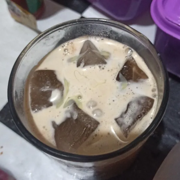 Masukkan cappuccino ke dalam gelas yang berisi es batu dan cokelat, beri kental manis lalu aduk.