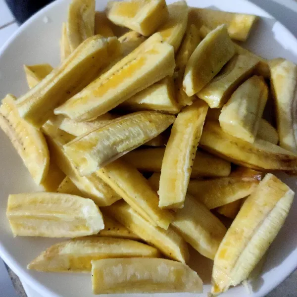 Potong-potong pisang uli, potong bagi dua lalu tiap potong belah menjadi 4 jadi satu pisang jadi 8 pcs.