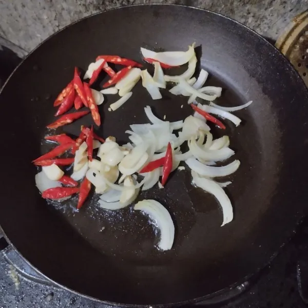 Tumis bawang bombay, bawang putih dan cabai merah keriting hingga harum.
