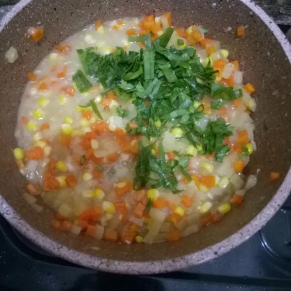 Masukkan jagung, kentang, wortel, daun bawang dan seledri iris. Tambahkan kental manis dan aduk rata. Masak hingga matang, empuk, rasanya pas, dan lengket. Kemudian angkat dan dinginkan.