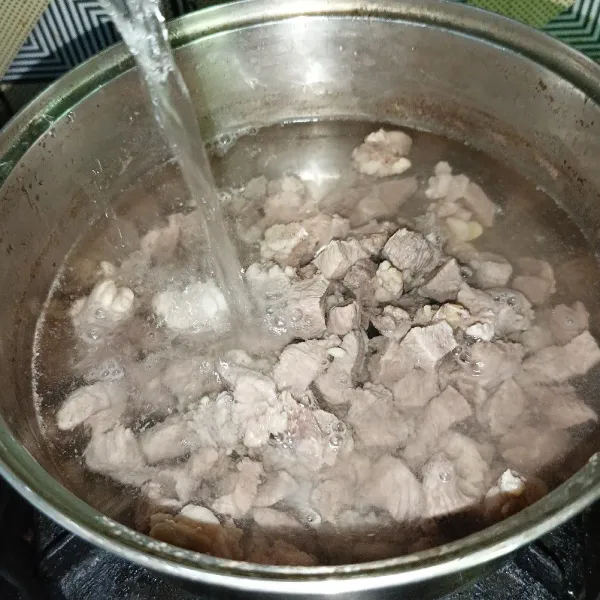 Lalu buang air rebusan pertama dan ganti dengan air baru secukupnya, rebus lagi sampai daging kambing empuk.