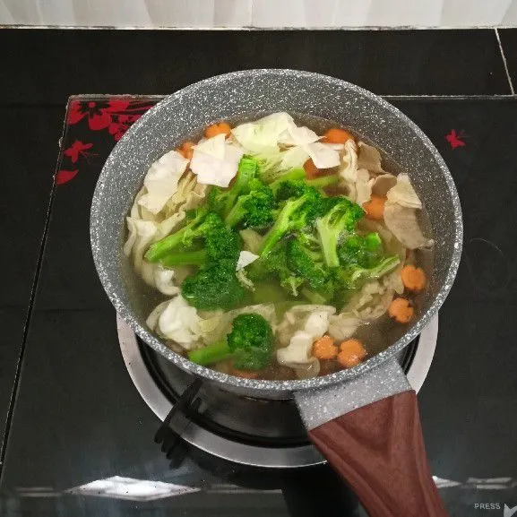 Kemudian masukkan kubis, brokoli, merica bubuk, kaldu bubuk, gula pasir dan garam. Aduk rata, masak hingga mendidih.