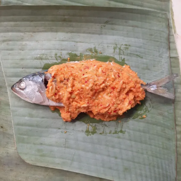 Bungkus ikan beserta bumbu menggunakan daun pisang.