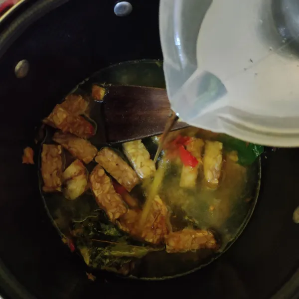Masukkan tempe, aduk rata. Lalu tambahkan air, kaldu bubuk, garam dan gula pasir. Masak hingga mendidih, tes rasa.