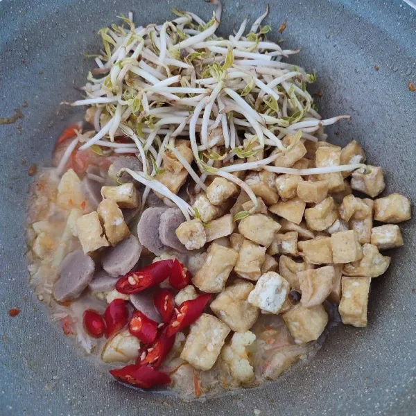 Masukkan tahu goreng, irisan bakso, tauge dan irisan cabe merah keriting. Tumis hingga tauge layu.