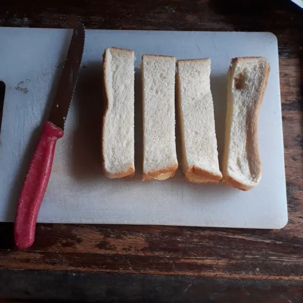 Tumpuk roti agar lebih mudah dipotong. Potong roti menjadi 4 bagian.
