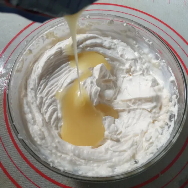 Kocok whipped cream, tambahkan kental manis, kocok sampai kaku.