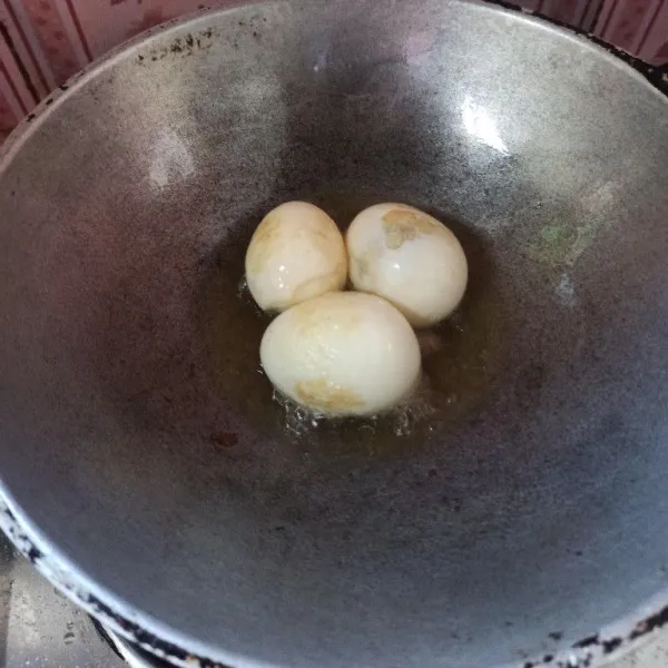 Kupas telur rebus kemudian goreng hingga berkulit.