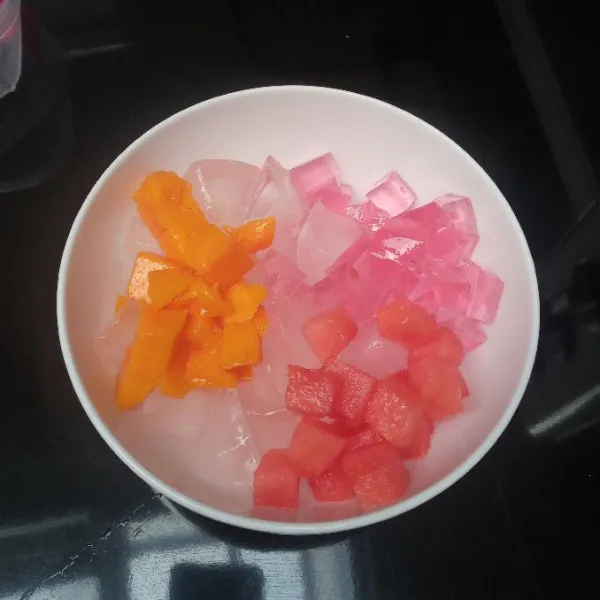 Dalam mangkuk masukkan es batu, buah, dan jelly.