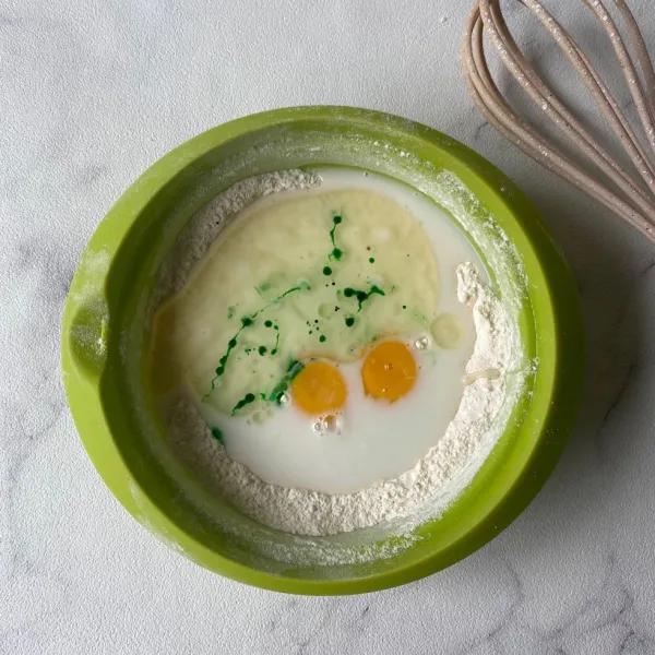 Tambahkan telur, susu cair, margarin cair, dan pasta pandan. Aduk menggunakan whisk sampai larut dan licin. Diamkan selama 10 menit.