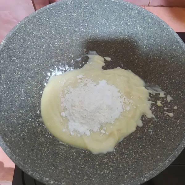 Tuang jus durian ke dalam wajan lalu masukkan tepung terigu dan tepung maizena. Aduk hingga tercampur rata.