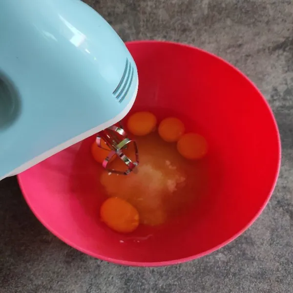 Mixer telur dan gula pasir hingga putih kental dan berjejak.