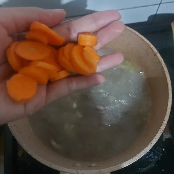 Masukkan potongan wortel, masak hingga wortel empuk.