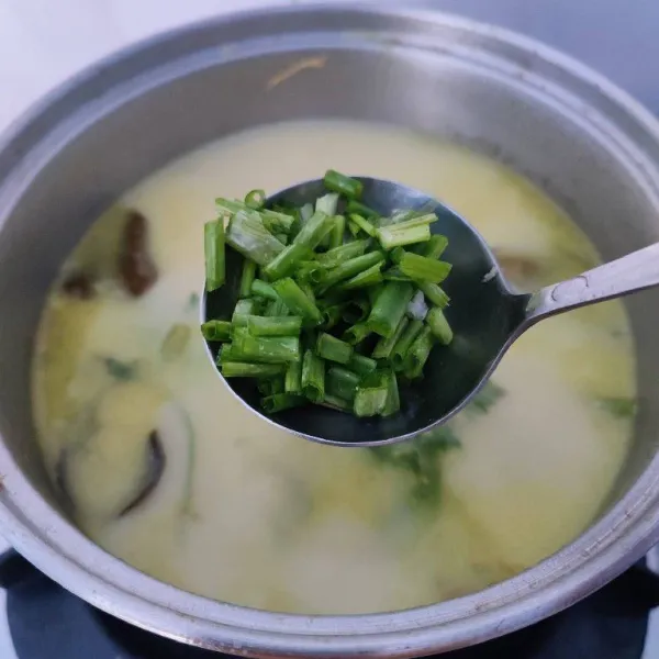 Tambahkan irisan daun bawang bagian hijau sesaat sebelum kompor dimatikan. Sajikan soto dengan bahan pelengkapnya.