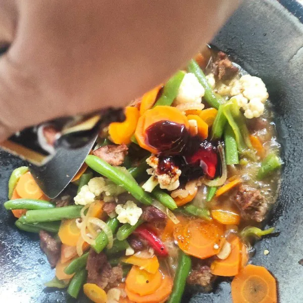 Masukkan saus lada hitam, garam, gula, saus sambal, tomat, dan kecap. Aduk rata, masak hingga meresap.