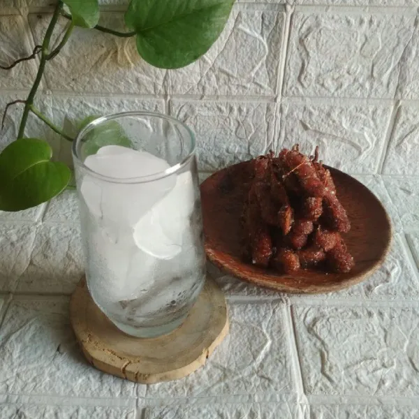 Siapkan es batu di gelas saji.