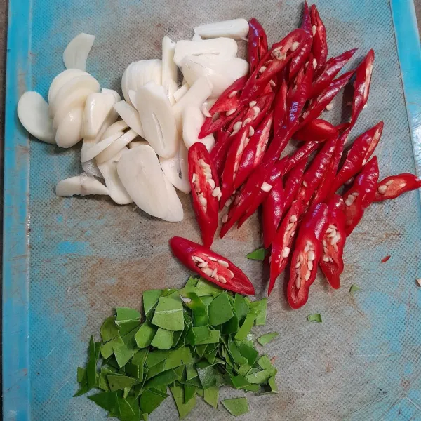 Iris cabe merah, bawang putih, dan daun jeruk.