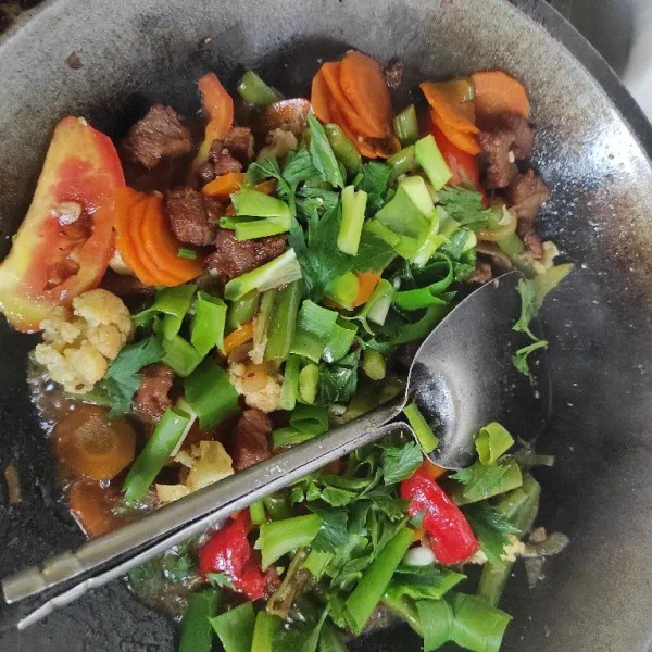 Tambahkan tomat, daun bawang dan seledri. Aduk sebentar, koreksi rasa. Sapi lada hitam siap disajikan.