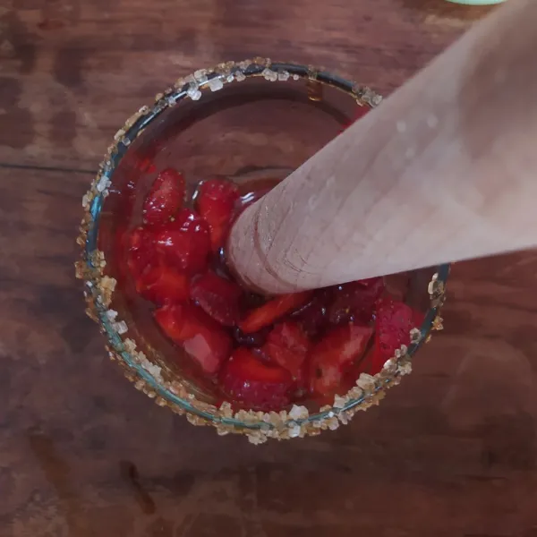 Beri secukupnya madu ke dalam gelas.
Masukkan strawbery, hancurkan dengan kayu rolling pin.