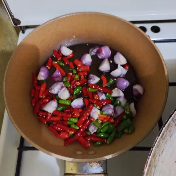 Panaskan minyak secukupnya masukan irisan bawang merah, cabai rawit, dan cabai merah keriting.
